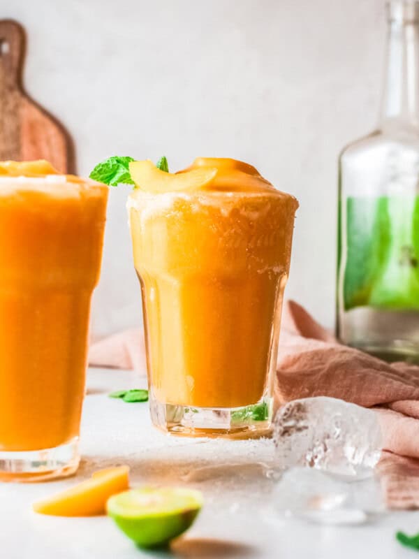 two glasses of frozen peach margaritas