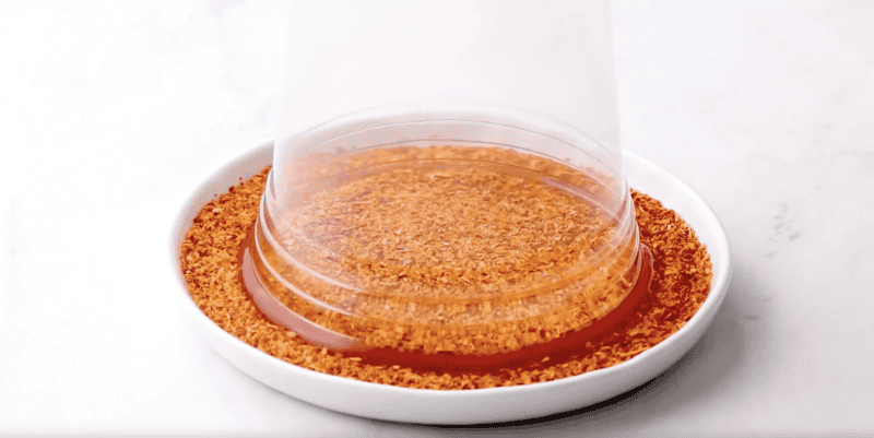 dipping a chamoy-coated glass into tajin.