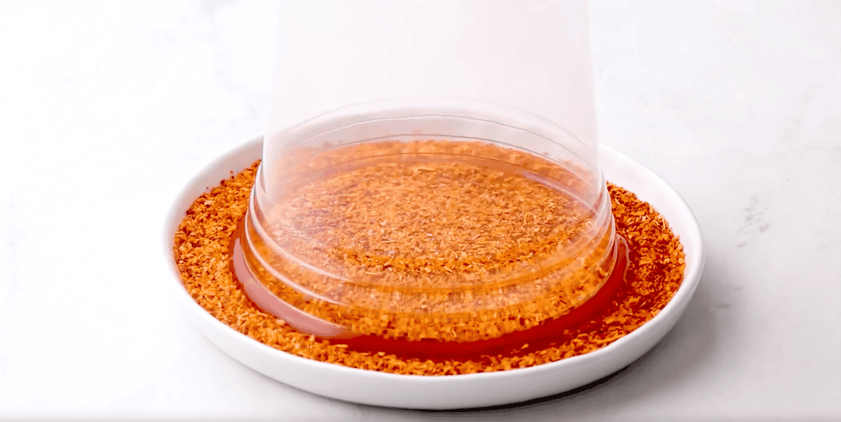 dipping a chamoy-coated glass into tajin.