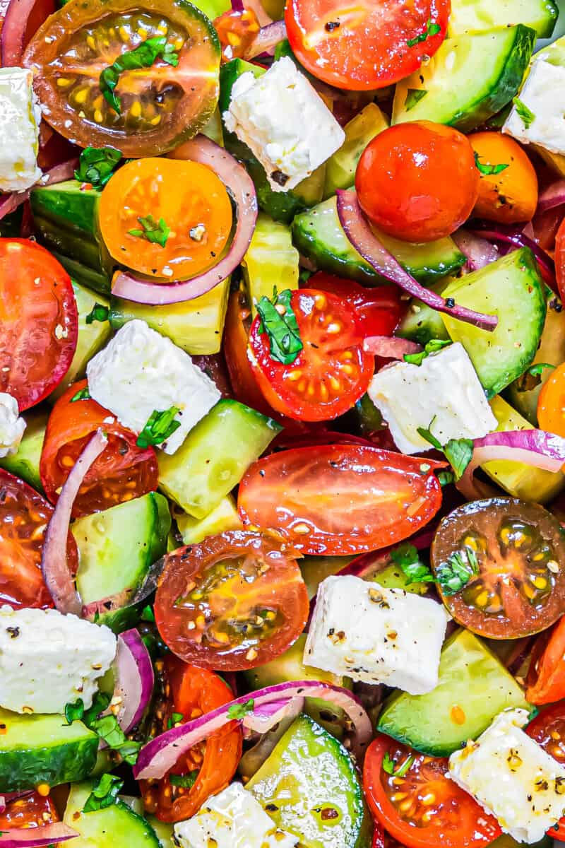 up close cucumber tomato salad in bowl with feta