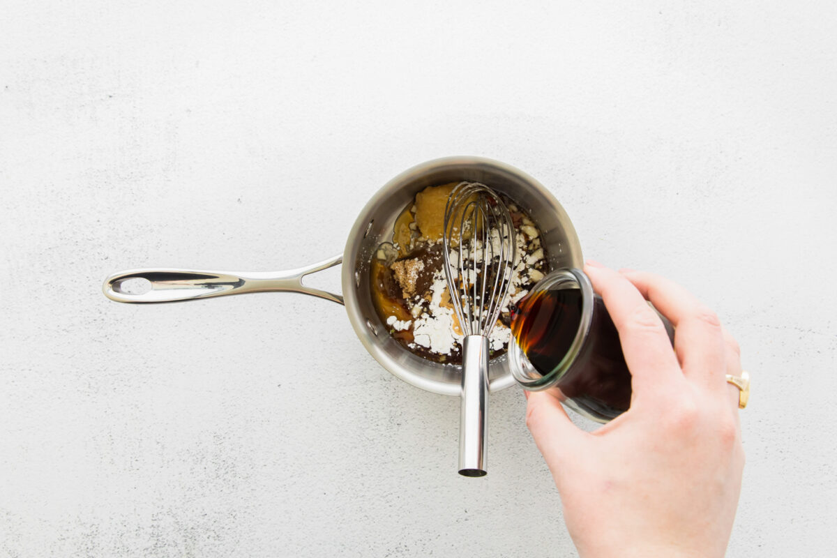 air fryer teriyaki tofu sauce ingredients in a saucepan with a whisk.