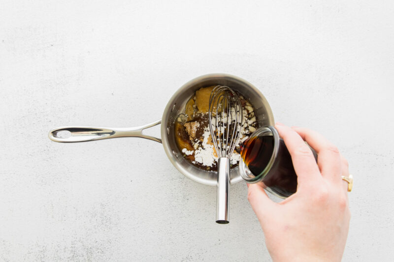 air fryer teriyaki tofu sauce ingredients in a saucepan with a whisk.