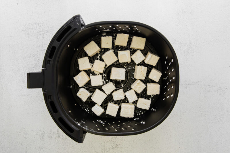 cubes of air fryer teriyaki tofu in an air fryer basket.