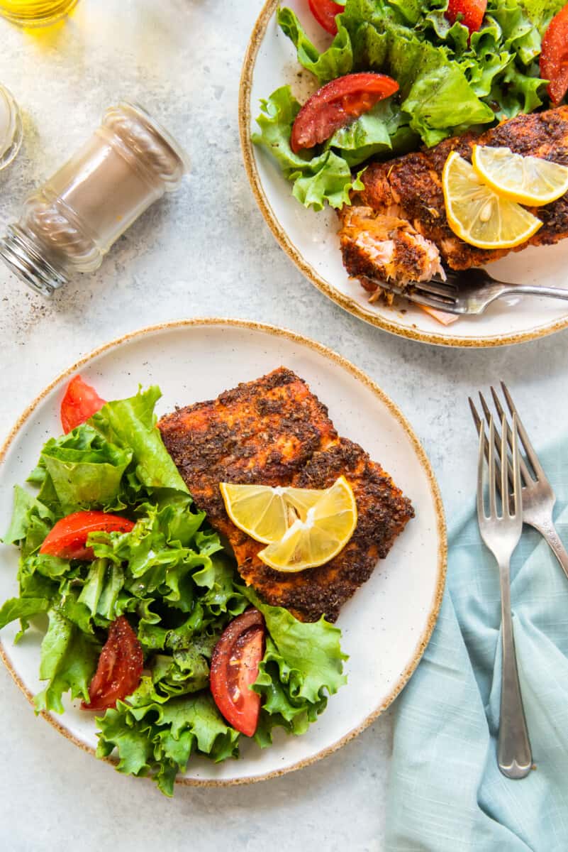 air fried salmon on plates with salad