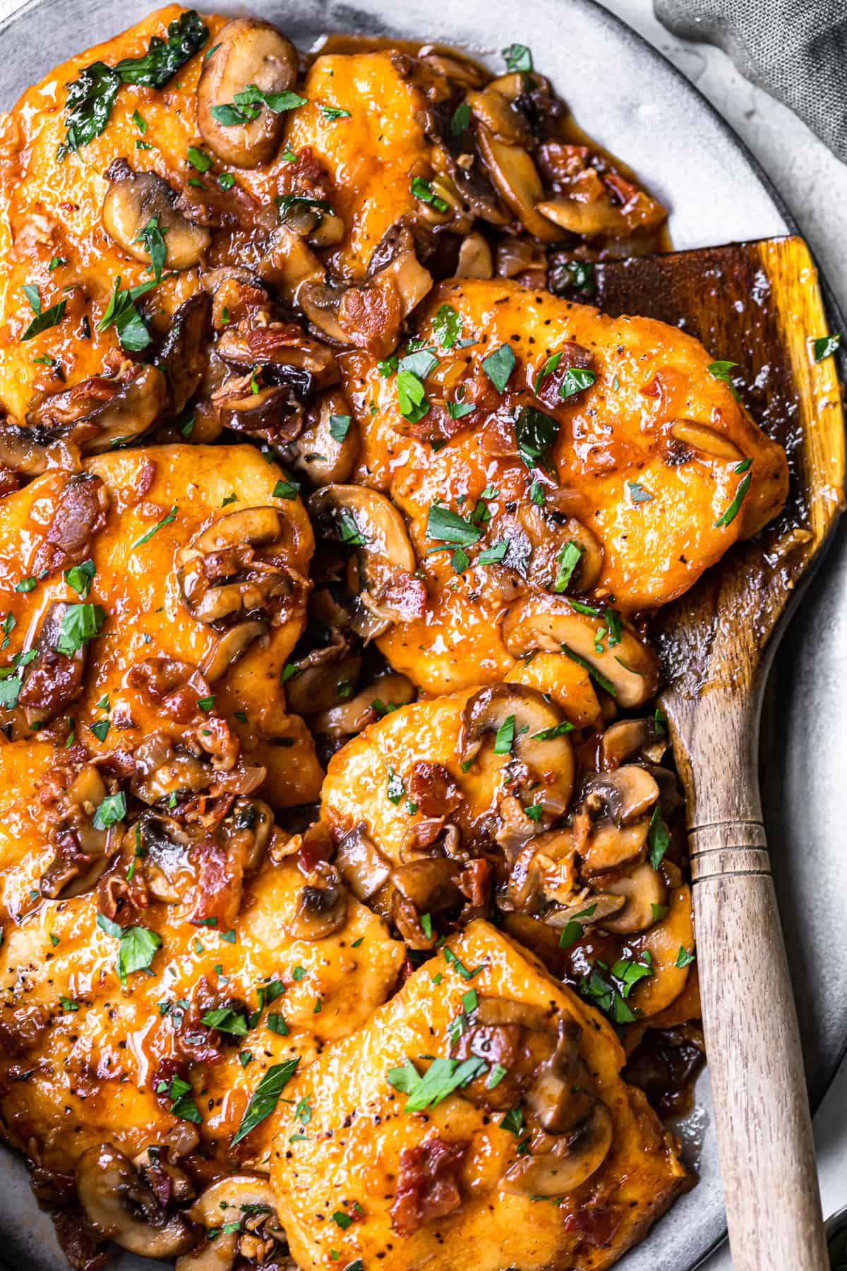 chicken marsala on platter with wooden spoon