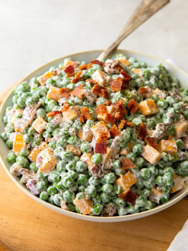 bowl of creamy pea salad topped with bacon