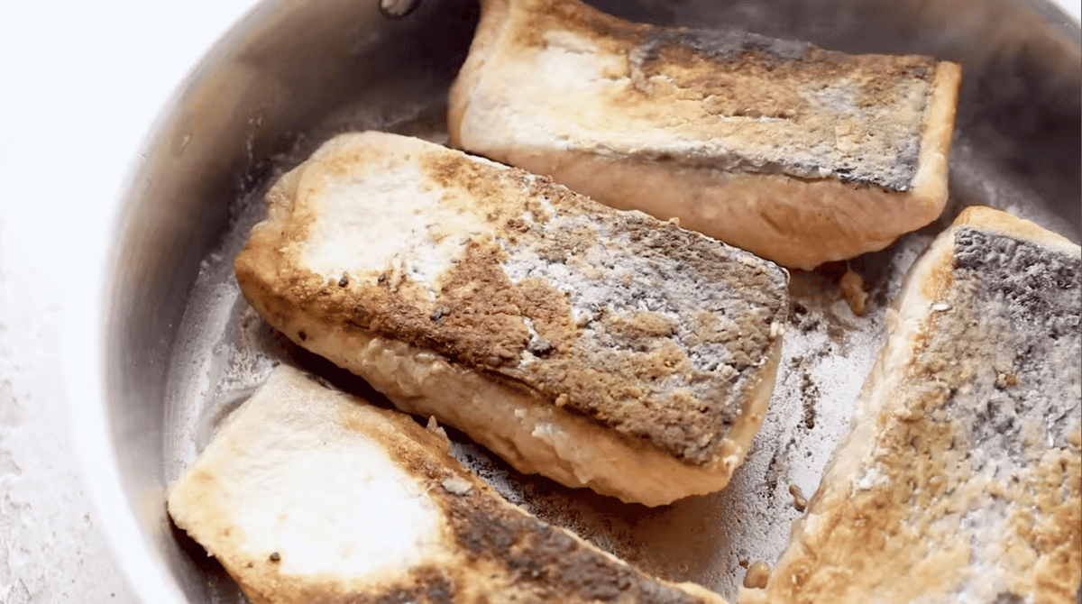 seared salmon fillets in a pan.