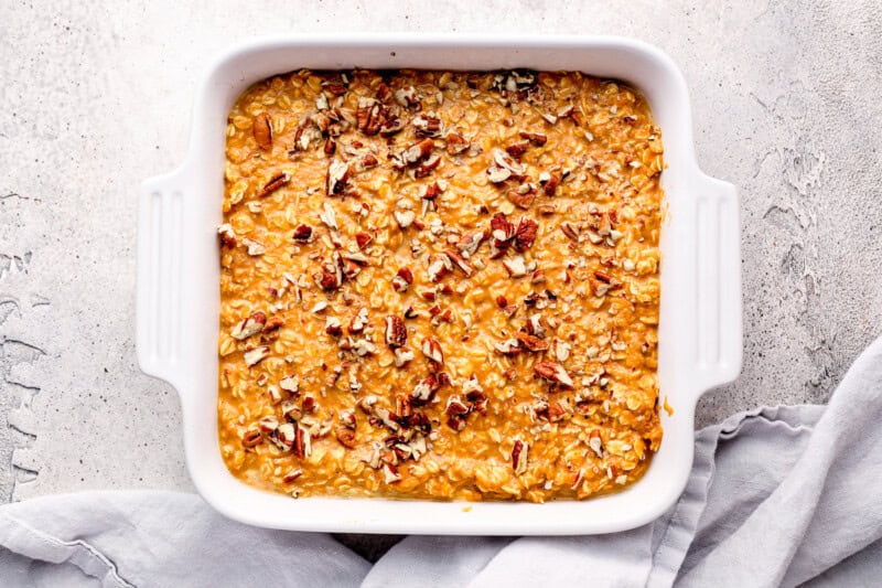 unbaked pumpkin oatmeal in a baking dish with pecans.