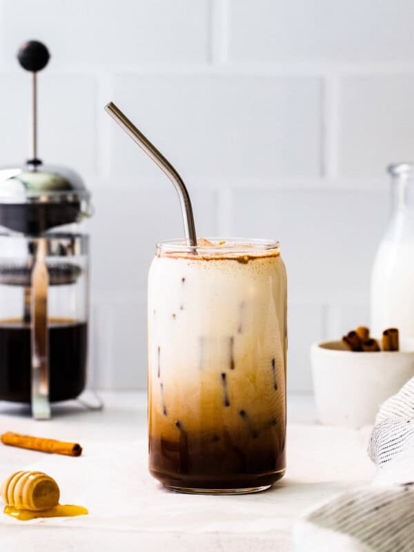 glass of iced honey cinnamon latte with metal straw