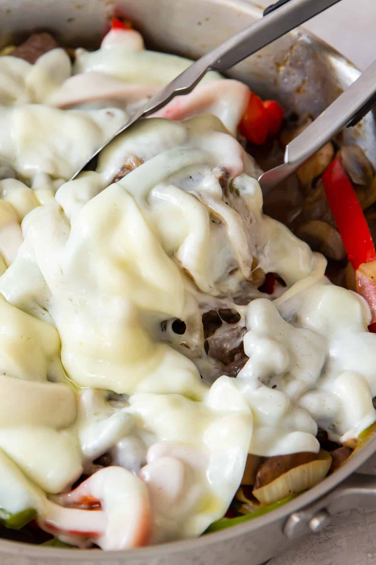 cheesy philly cheesesteak meat in skillet