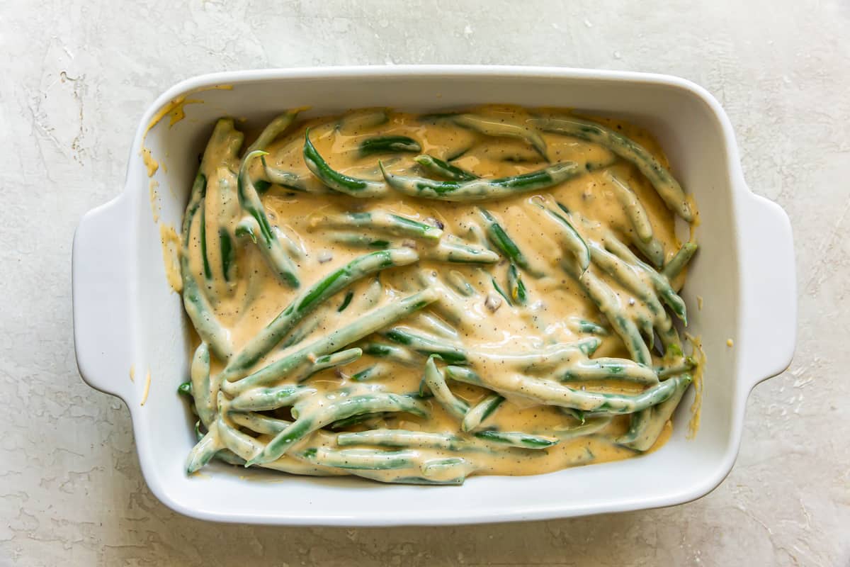 green beans coated in a creamy sauce in a baking dish.