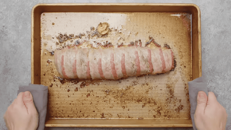 baked bacon wrapped pork tenderloin on a baking sheet.