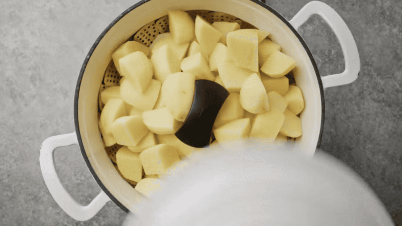 steaming cubed potatoes in a Dutch oven.