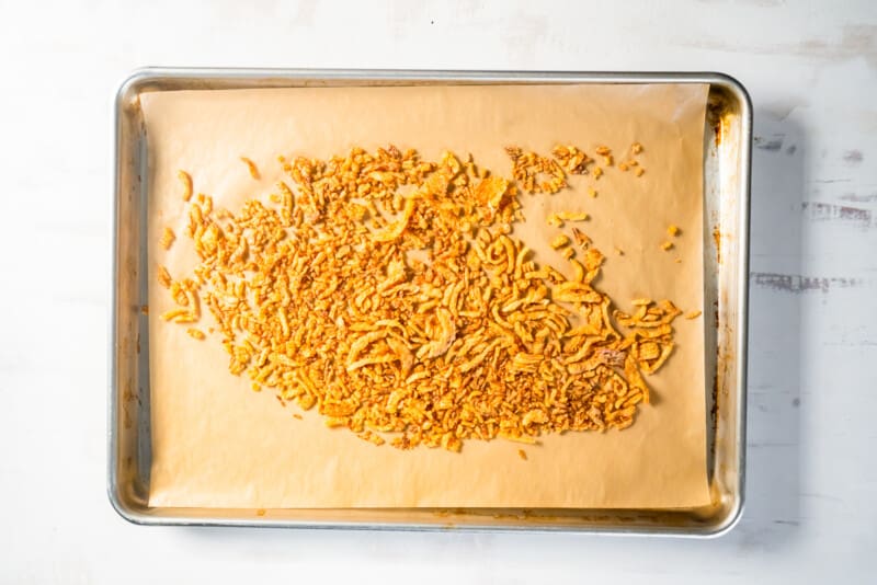 french fried onions on a piece of parchment paper on a baking sheet