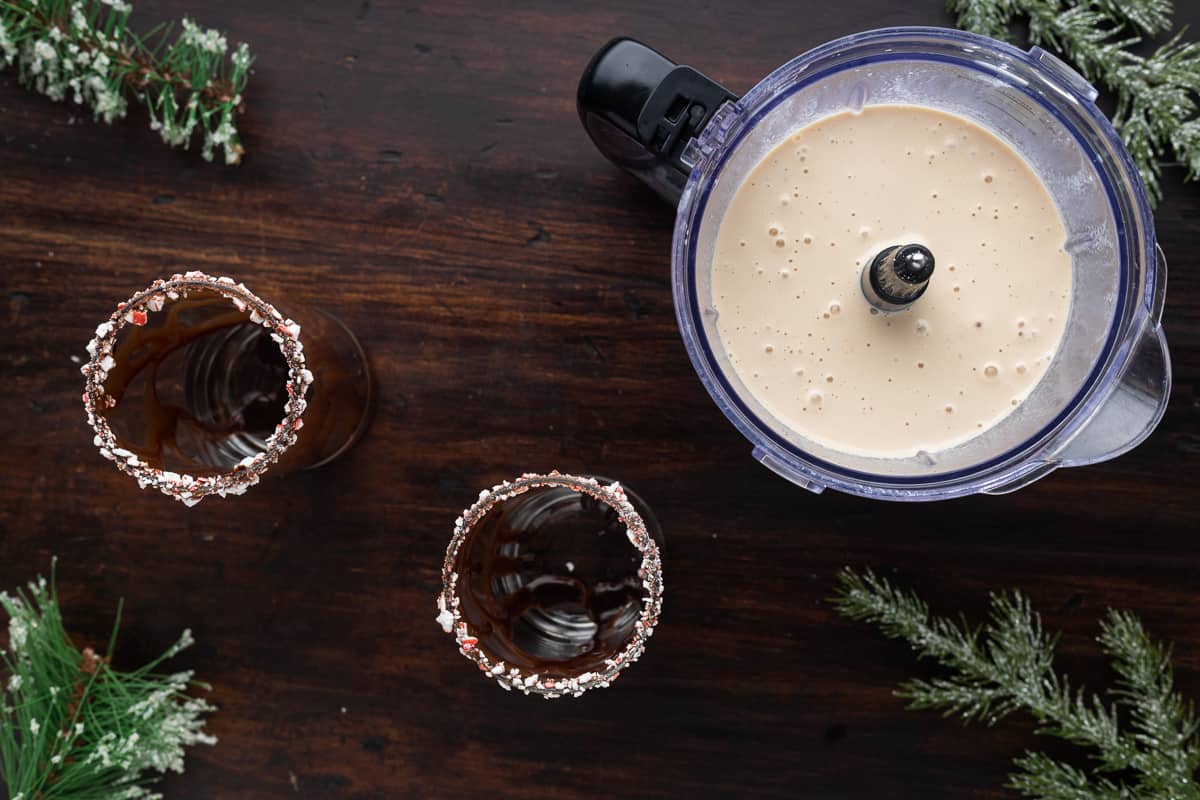 Two glasses rimmed with peppermint and drizzled with chocolate.