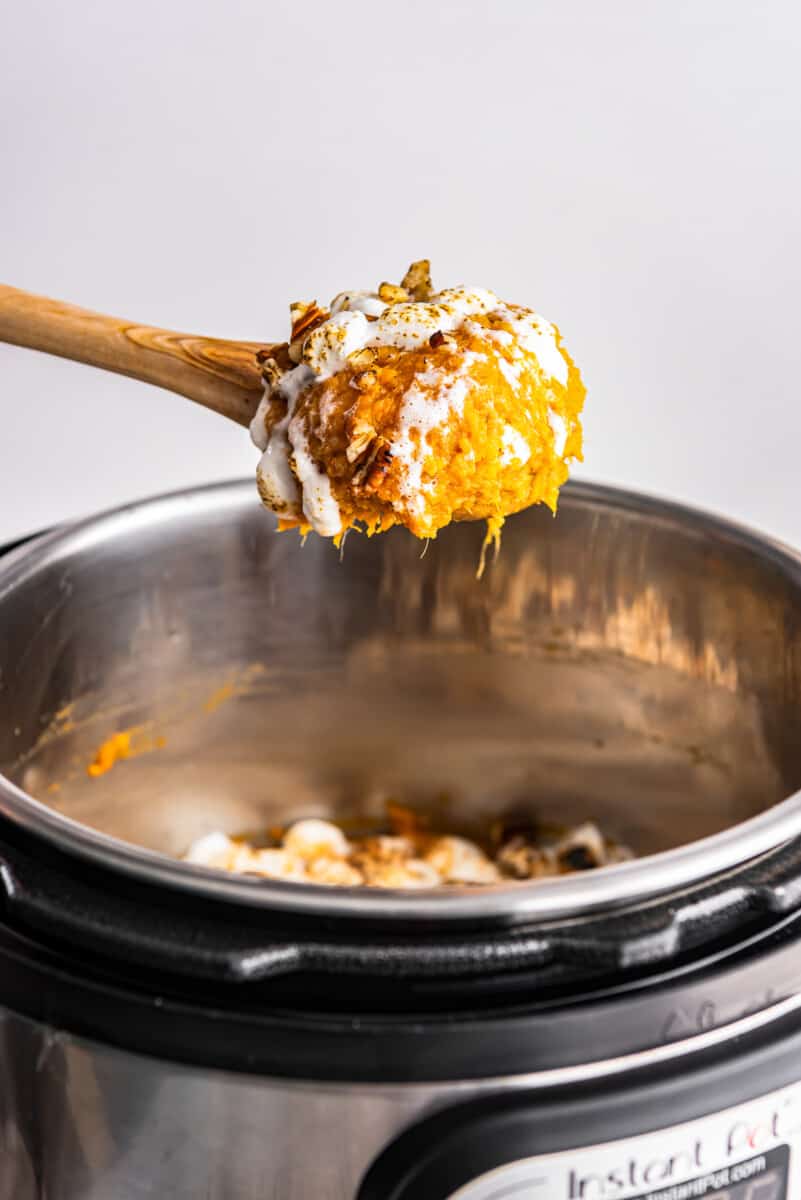 wood spoon with a serving of sweet potato casserole