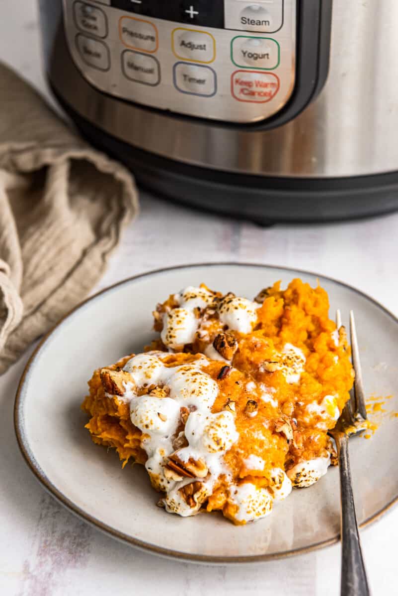 serving of sweet potato casserole on a white plate with a fork