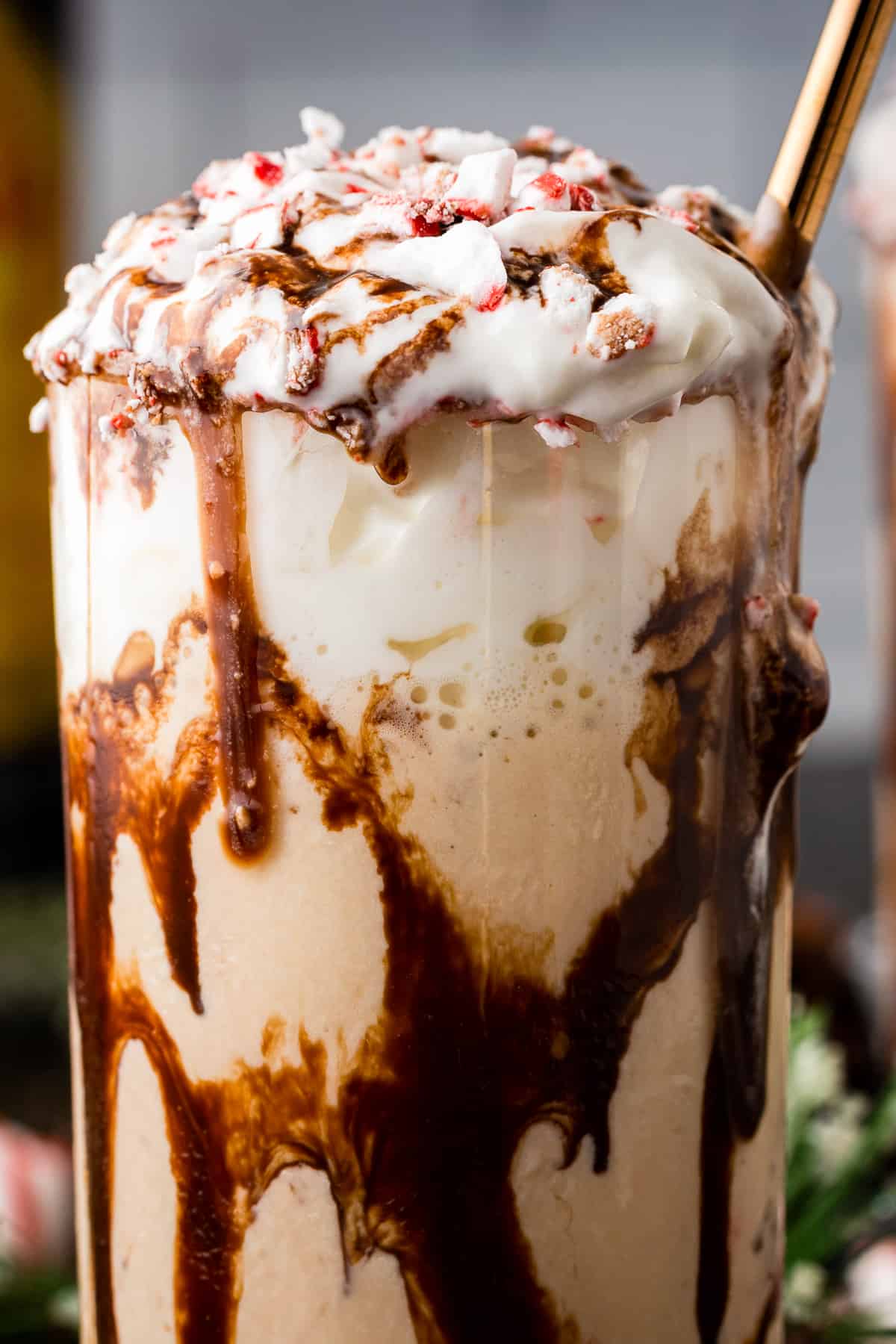 Close up on a peppermint mocha mudslide, with chocolate syrup dripping down the sides of the glass.