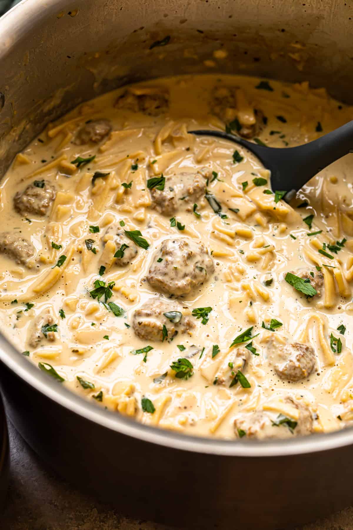 creamy swedish meatball soup in a pot with a ladle.