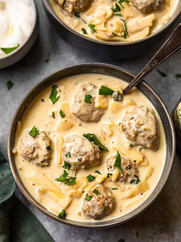 swedish meatball soup in a black bowl with a spoon