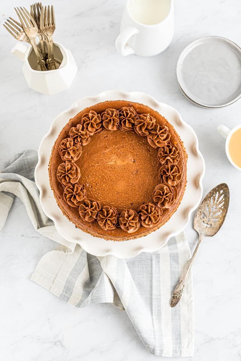 overhead image of chocolate cheesecake on a white cake stand