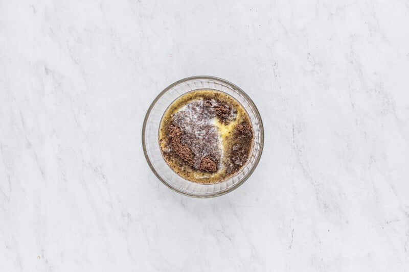 melted butter and crushed Oreo cookies in a glass bowl