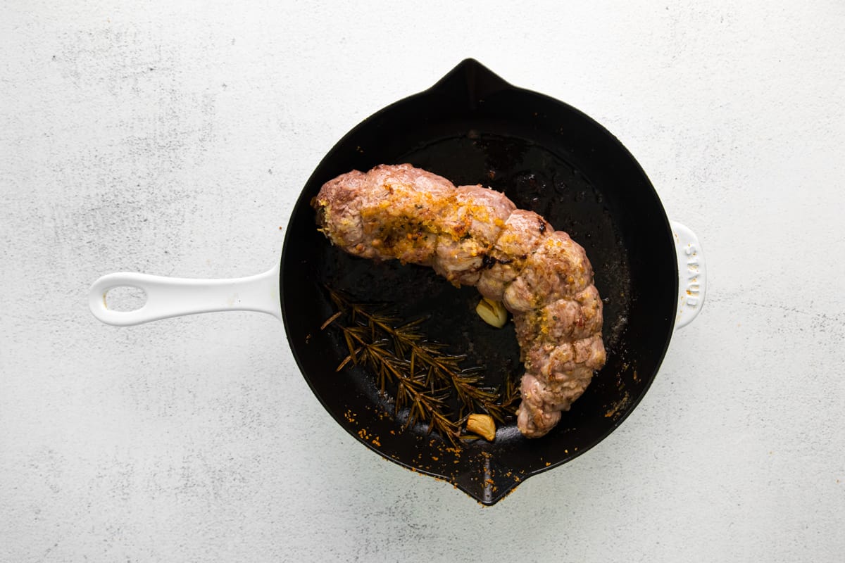 stuffed pork loin in a skillet after roasting