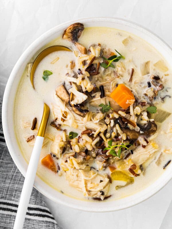 crockpot chicken wild rice soup in a white bowl with a spoon