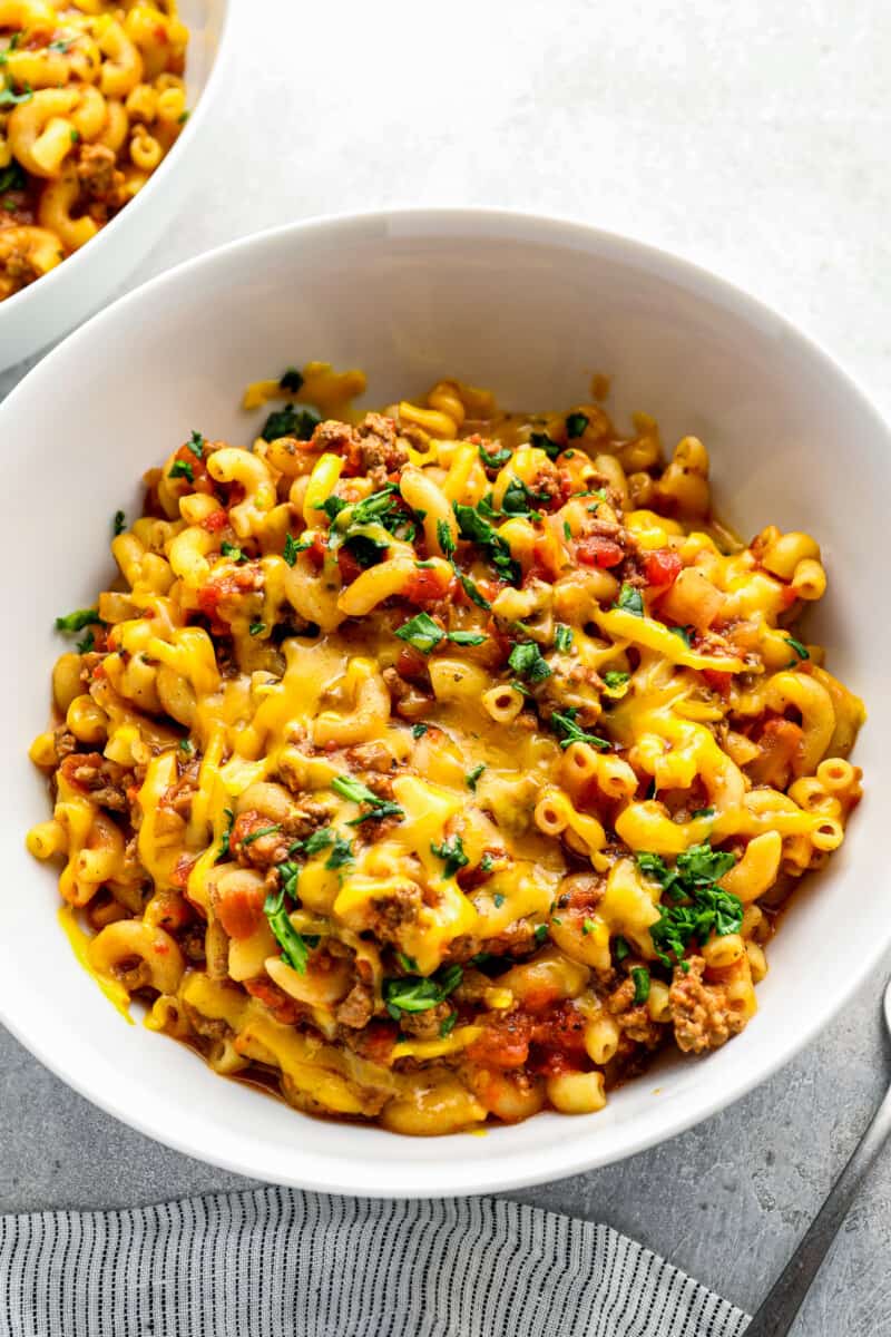 up close bowl of cheesy crockpot goulash on table