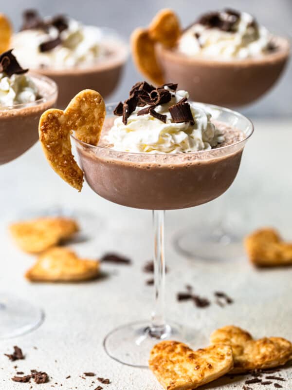 frozen french silk pie cocktails in glasses topped with whipped cream and chocolate shavings and garnished with baked pie crust cookies