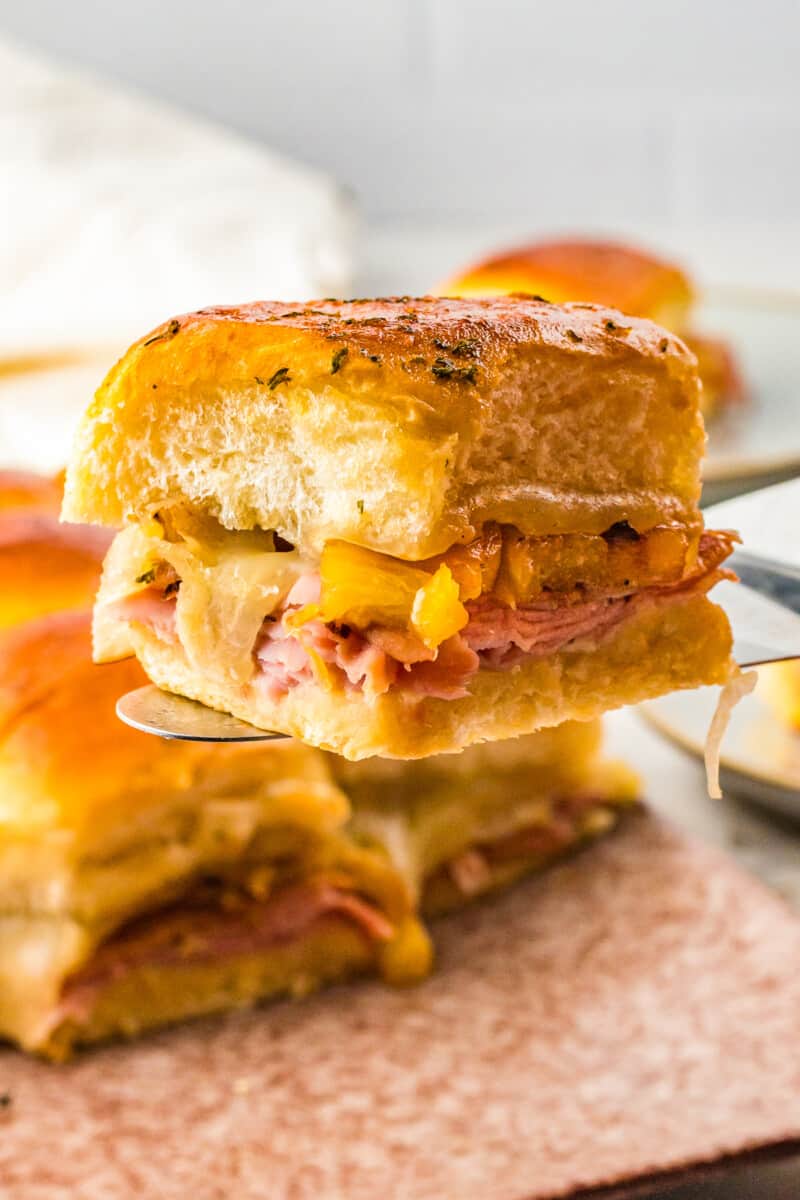 lifting up hawaiian ham and cheese slider