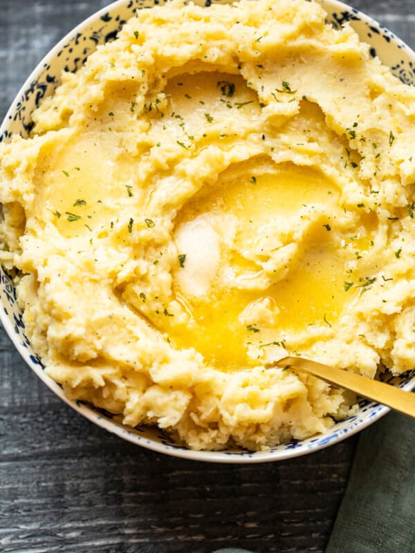 mashed potatoes in a bowl with butter on top with a spoon