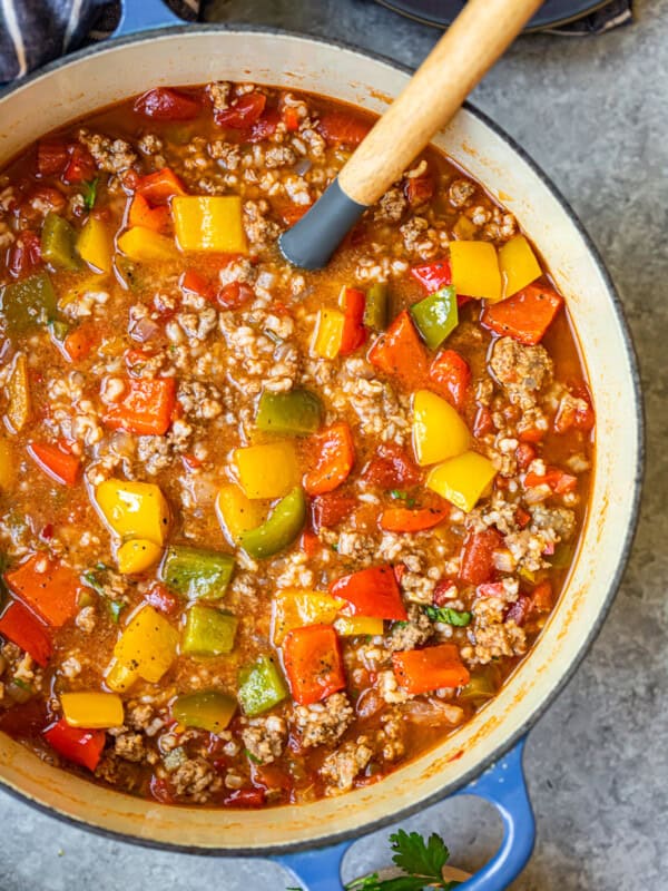 stuffed pepper soup in a blue dutch oven with a wood spoon