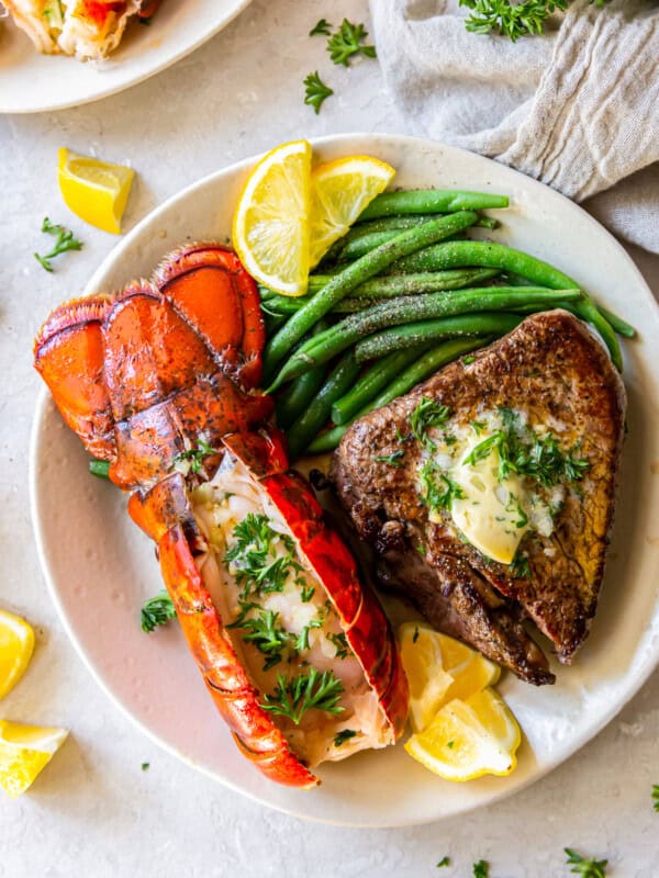 lobster tail and filet mignon with green beans on a plate