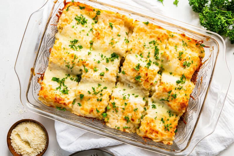 overhead image of chicken alfredo lasagna roll ups in a casserole dish