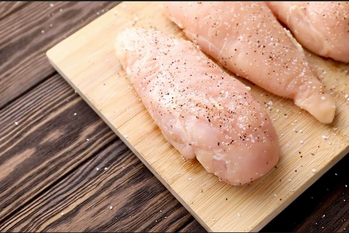 Chicken breast are seasoned with salt and pepper.