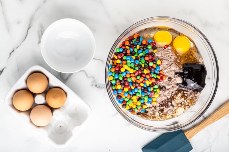 ingredients for M&M brownie cookies in a glass bowl