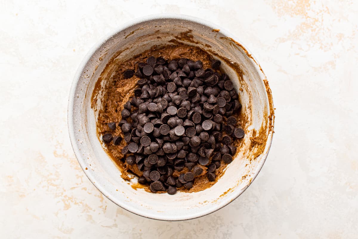 espresso morsels added to cookie dough in a white bowl