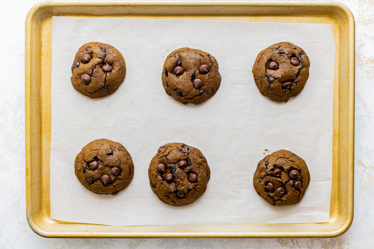 6 mocha cookies after baking on a baking sheet lined with parchment paper