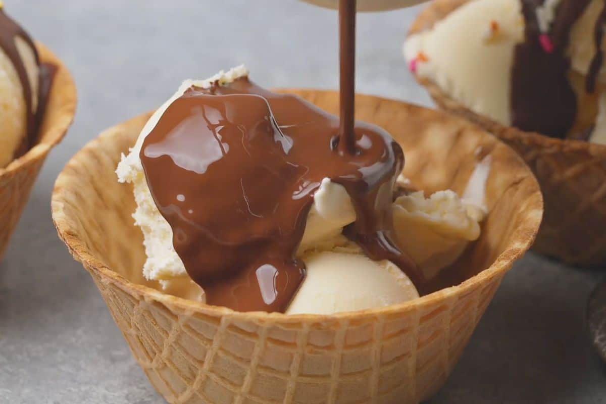 Pouring the chocolate sauce on ice cream.