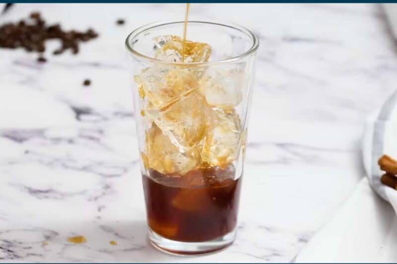 iced brown sugar espresso poured over glass filled with ice and top with unflavored oat milk.