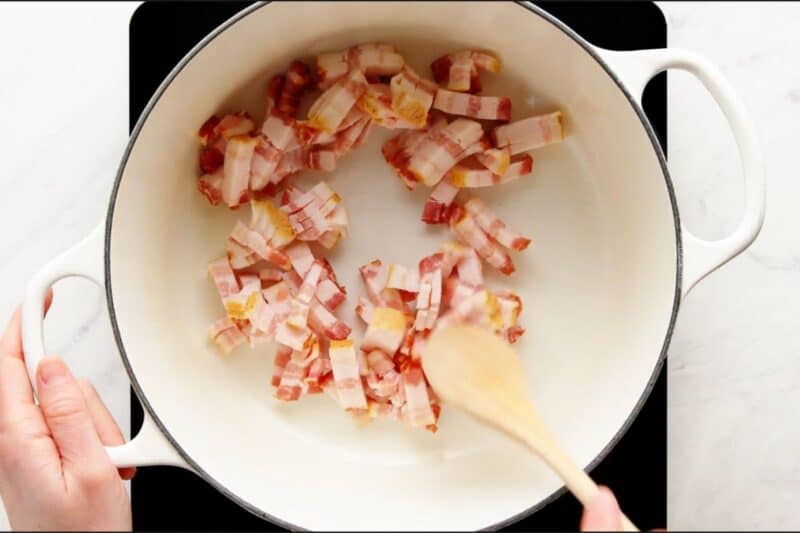 chopped bacon added in dutch oven Cooking until crisp with spatula.