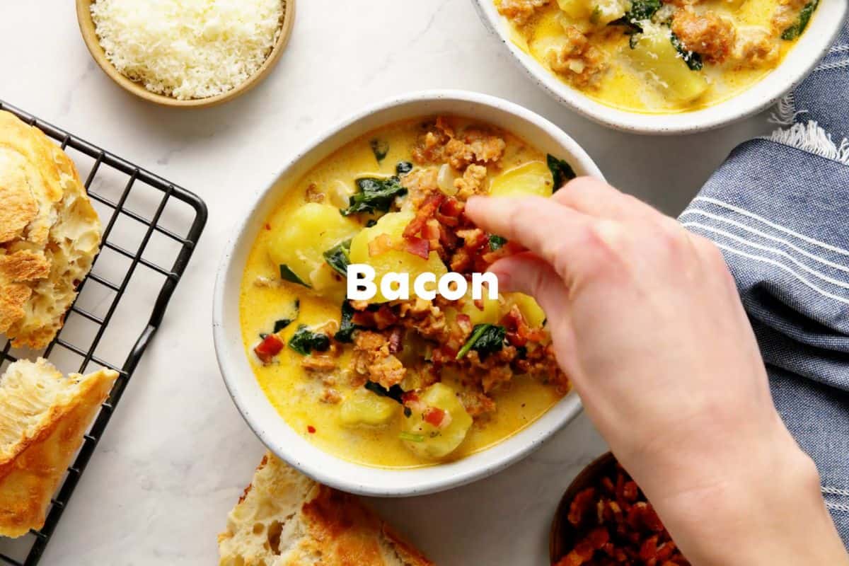 garnishing the copycat olive garden zuppa toscana soup bowl with crisp bacon.