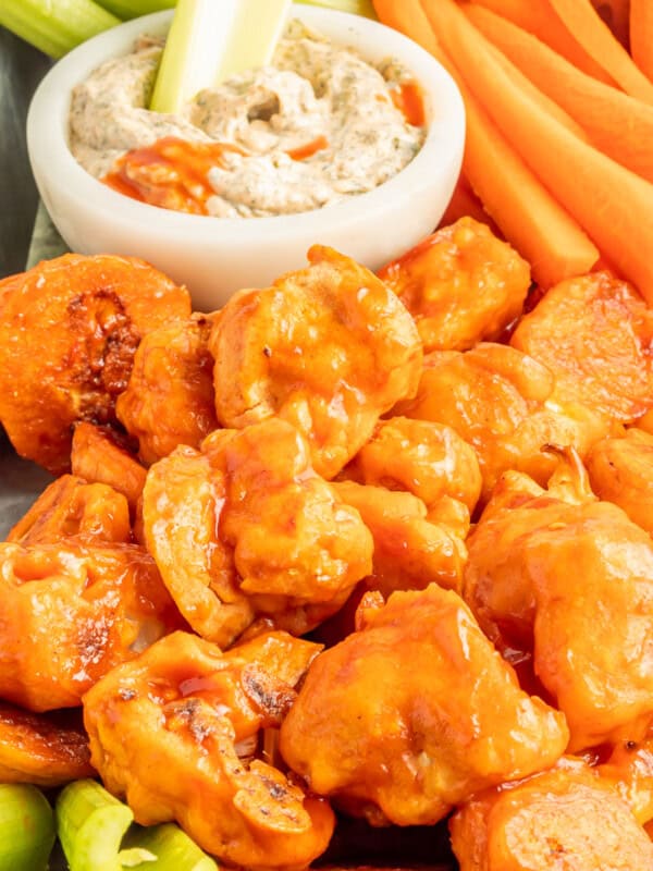 buffalo cauliflower wings on a serving tray with buffalo ranch dressing in a white bowl