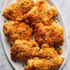 baked chicken thighs on a white serving plate