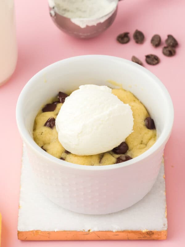 chocolate chip cookie in a mug topped with a scoop of vanilla ice cream