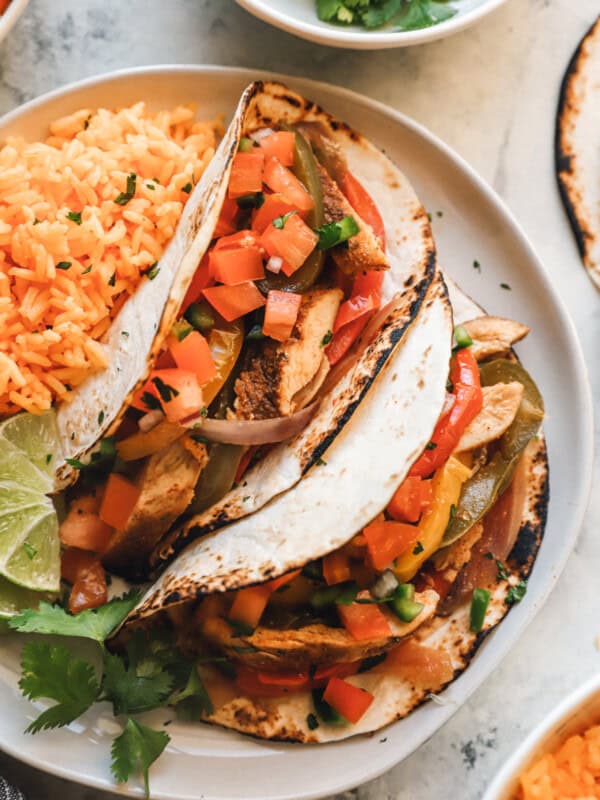 chicken fajitas on a white plate with rice