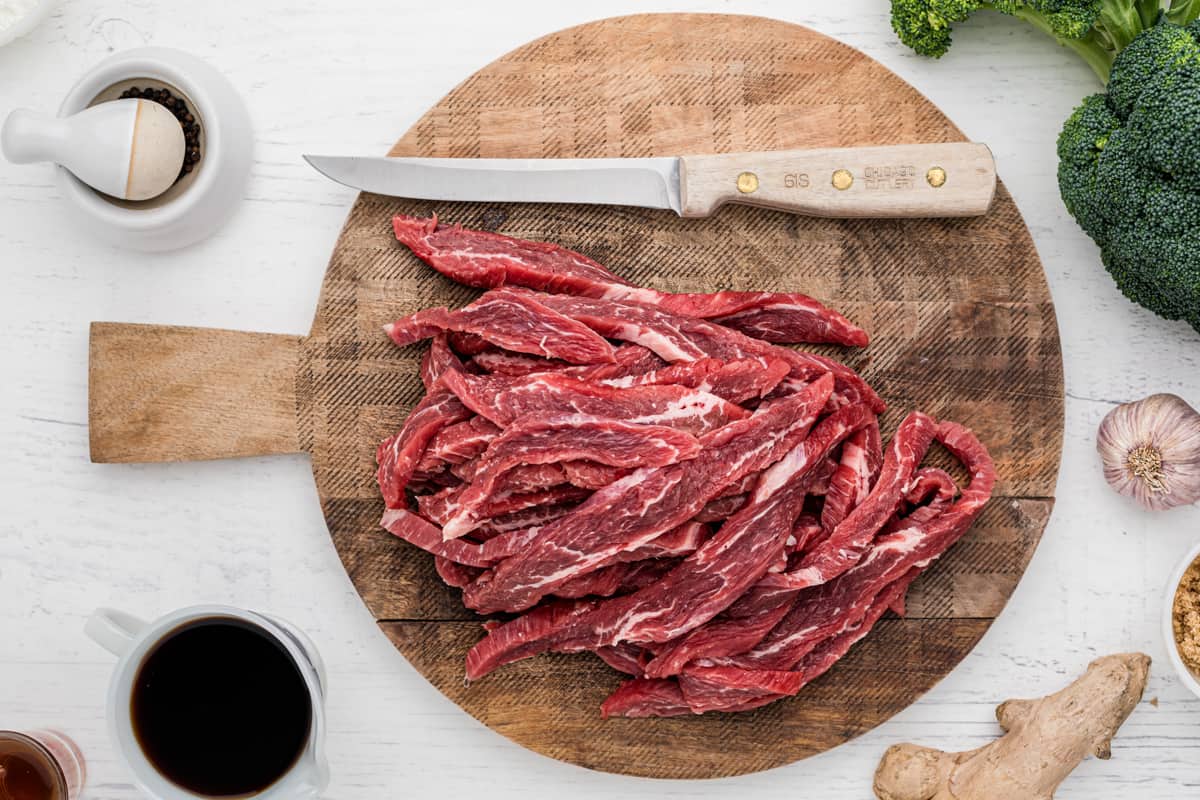 sliced flank steak on a wood cutting board