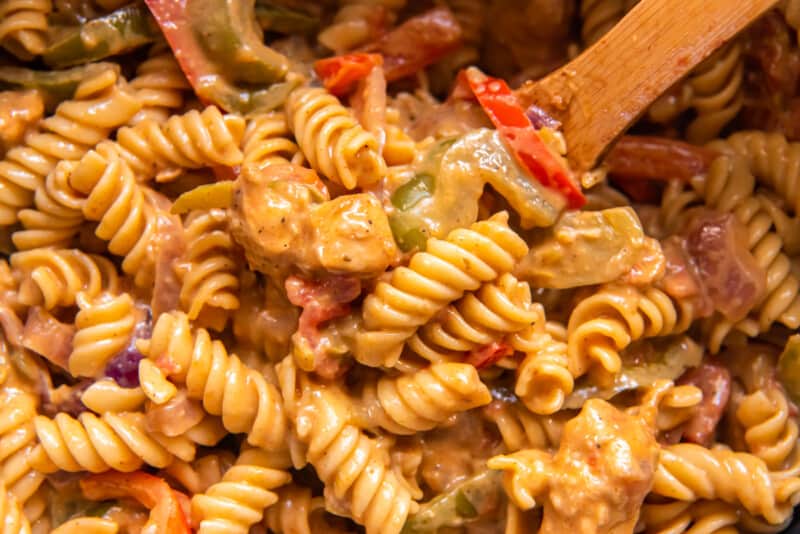 creamy chicken fajita pasta with a wood spoon