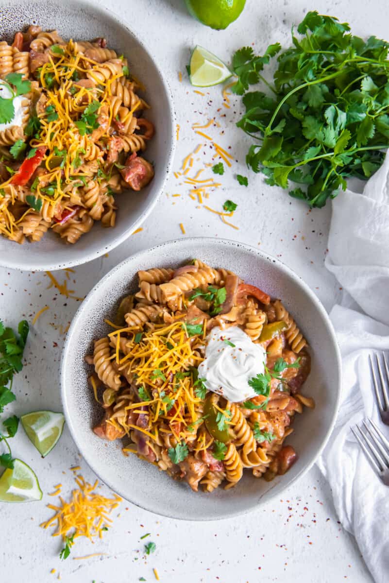 overhead image of chicken fajita pasta in 2 white bowls